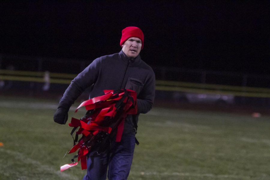 HOLD THE FLAG! Senior coach Mr. Madden runs over to the sideline to distribute the flags to his team. 