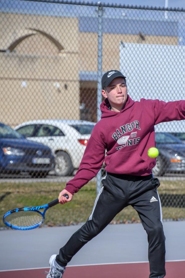 Senior Brayden Beltrano gets in position to send a forehand flying over the net to win the point. 