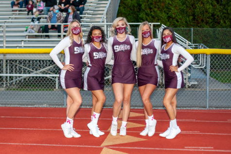 SENIOR SMILES! Slater senior cheerleaders quickly huddle and strike a pose before spreading Slater cheer! Though their gorgeous smiles are covered with a mask, the Slater mask remains the perfect choice of accessory. 