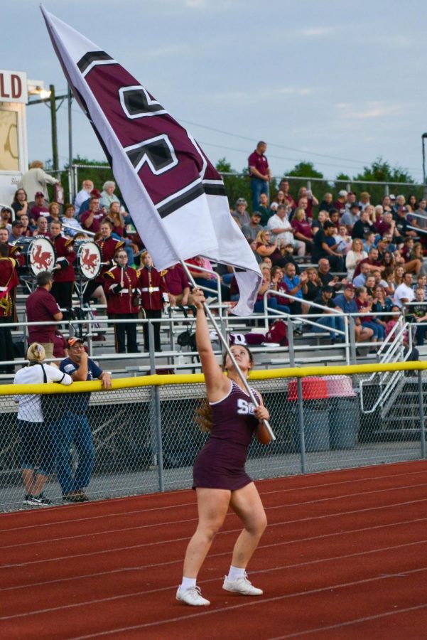 6 POINTS MORE! Senior Brooke Edwards runs the flag while the Slaters make their way to the end zone. Edwards took over flag duty at the beginning of her junior year and will now be passing on the special role to an underclassman.