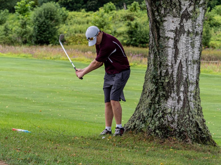 WOAH! Junior Thomas Buck lines up his shot to get the ball back on the green. During his third season on the BHS golf team, he improved and helped the team get out of some sticky situations. 