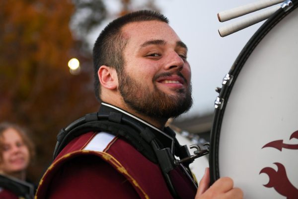 STRIKE A POSE!
Gavin Ulmer flashes a smile for the camera while proudly standing amidst the marching band, showcasing his enthusiasm for music and performance
