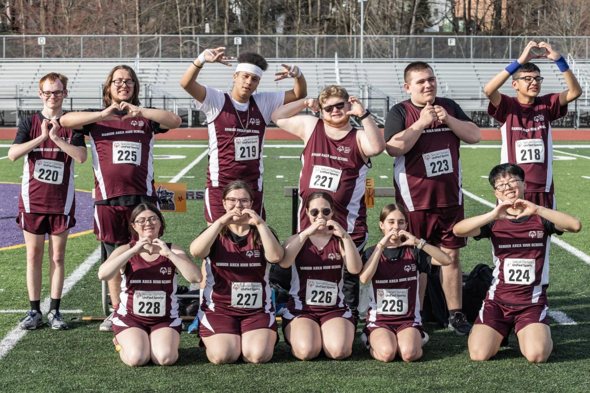 UNIFIED TRACK STIKES A POSE
The unified track team forms heart shapes with their hands, symbolizing their strong bond and collective passion for the sport.