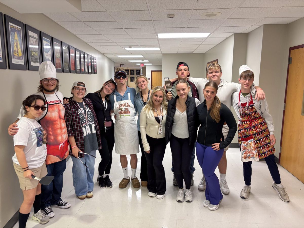 COOKOUTS VS. TOURNAMENTS. These spirited students pose as a group of BBQ dads and soccer moms, complete with aprons, spatulas, and even sunglasses. This group created the best showdown in rivalry week.